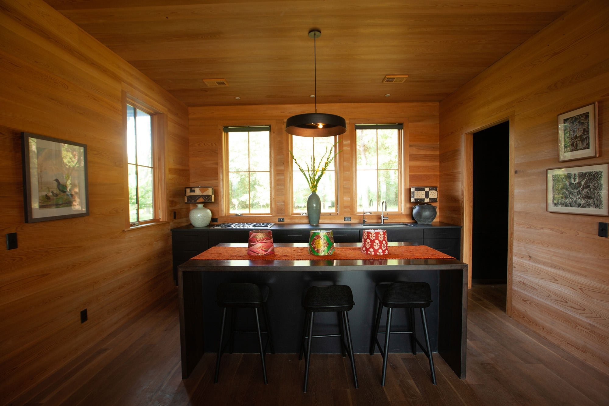 three lampshades on an island in the middle of a room with three bar stools