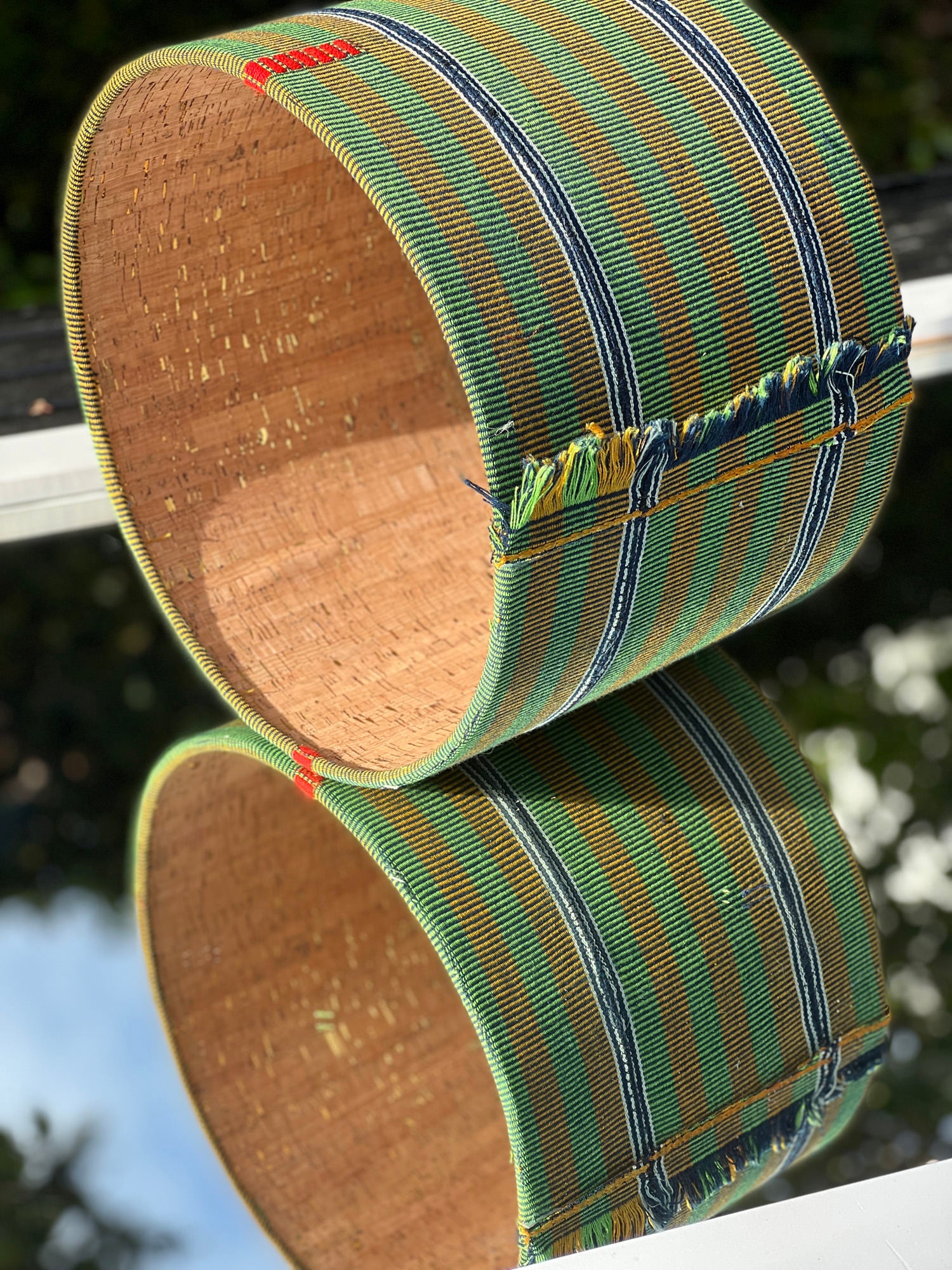 beautiful custom made lampshade with green fabric sitting on a mirror