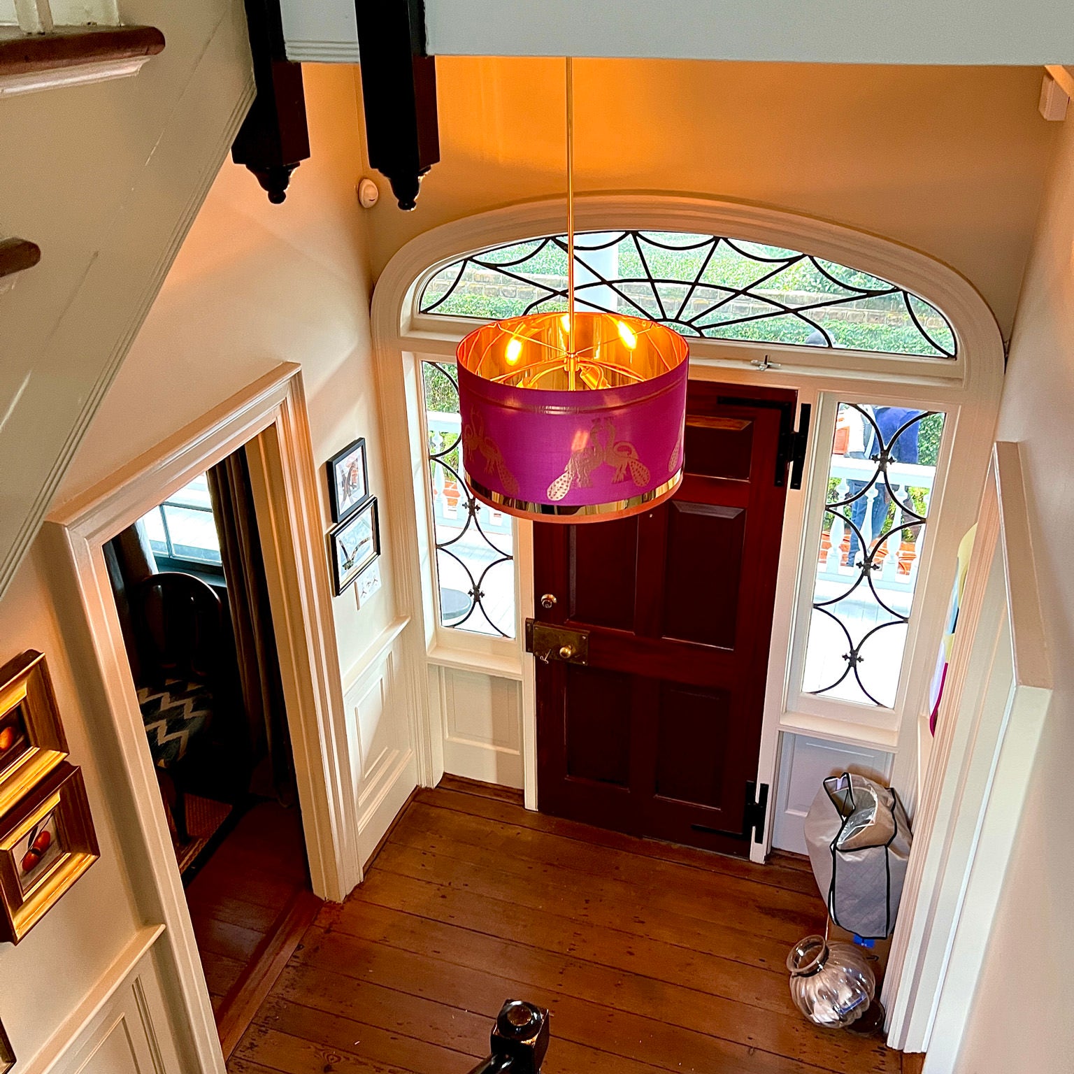 pink lampshade an light hung in a foyer