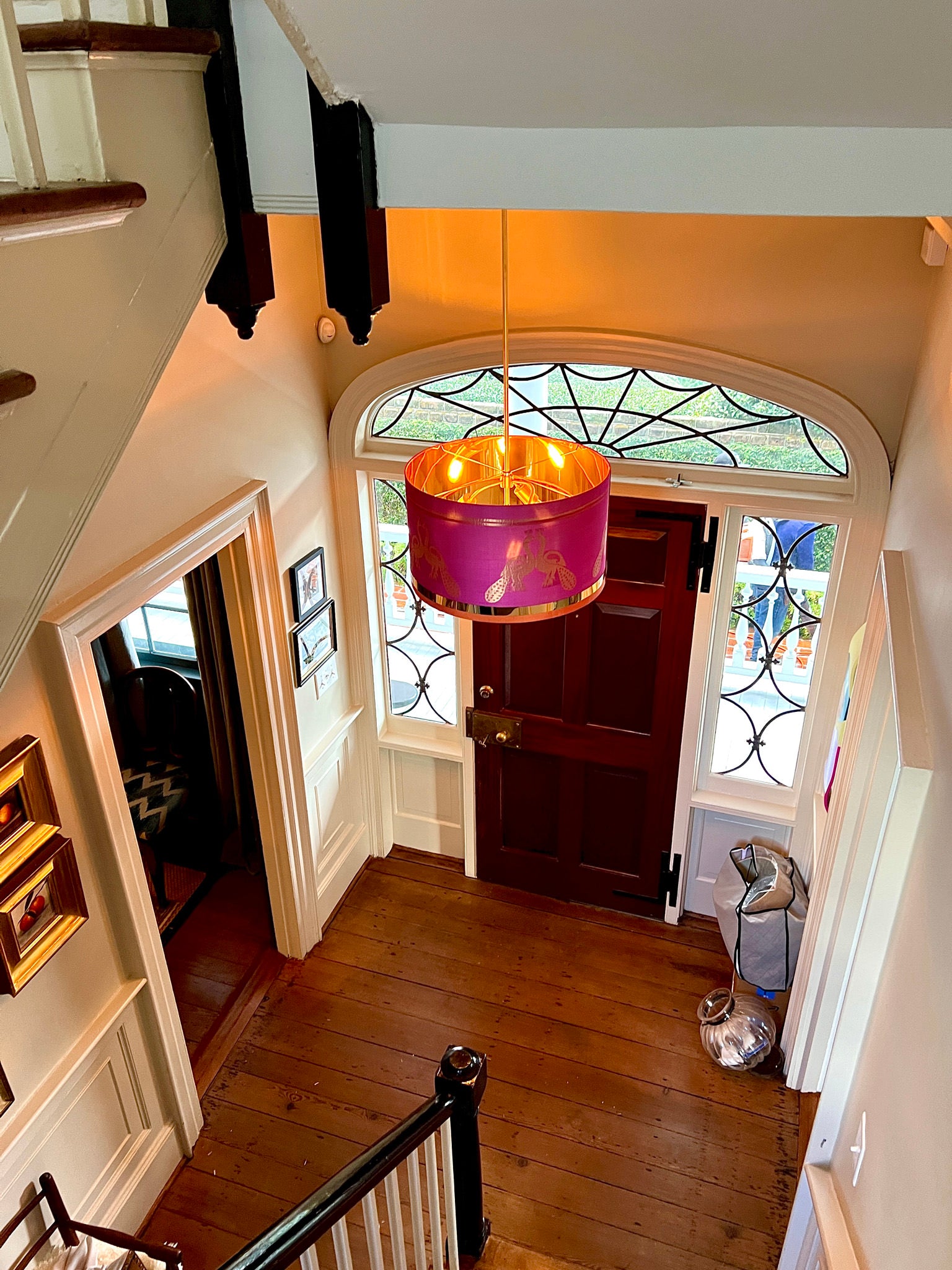 pink lampshade an light hung in a foyer