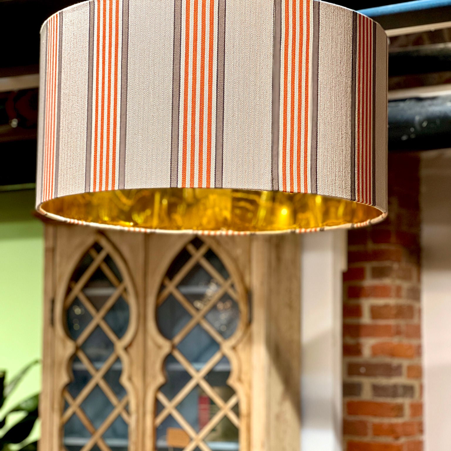 orange, brown and beige lamp shade with buffet shelf in background