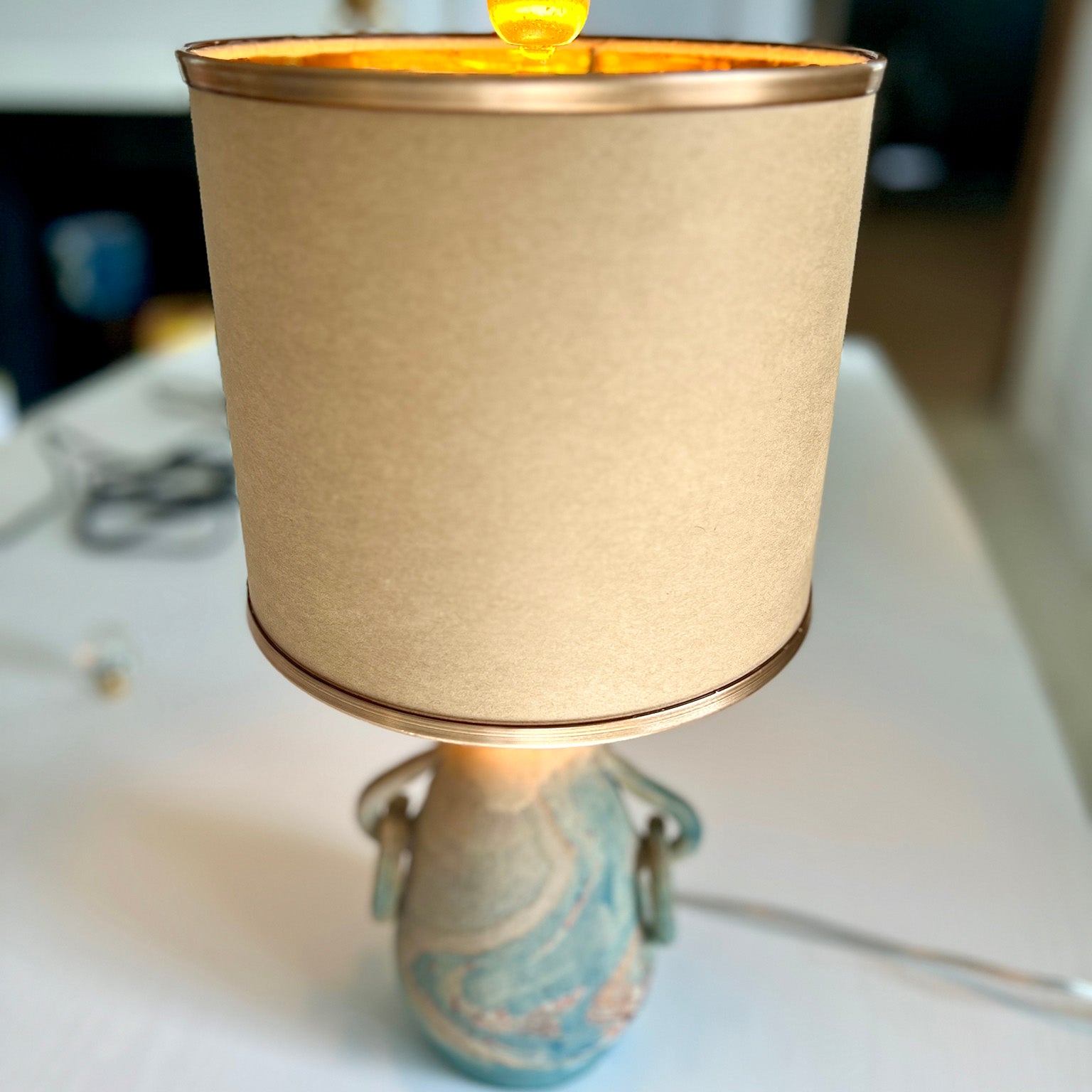beige lampshade with gold piping on lamp