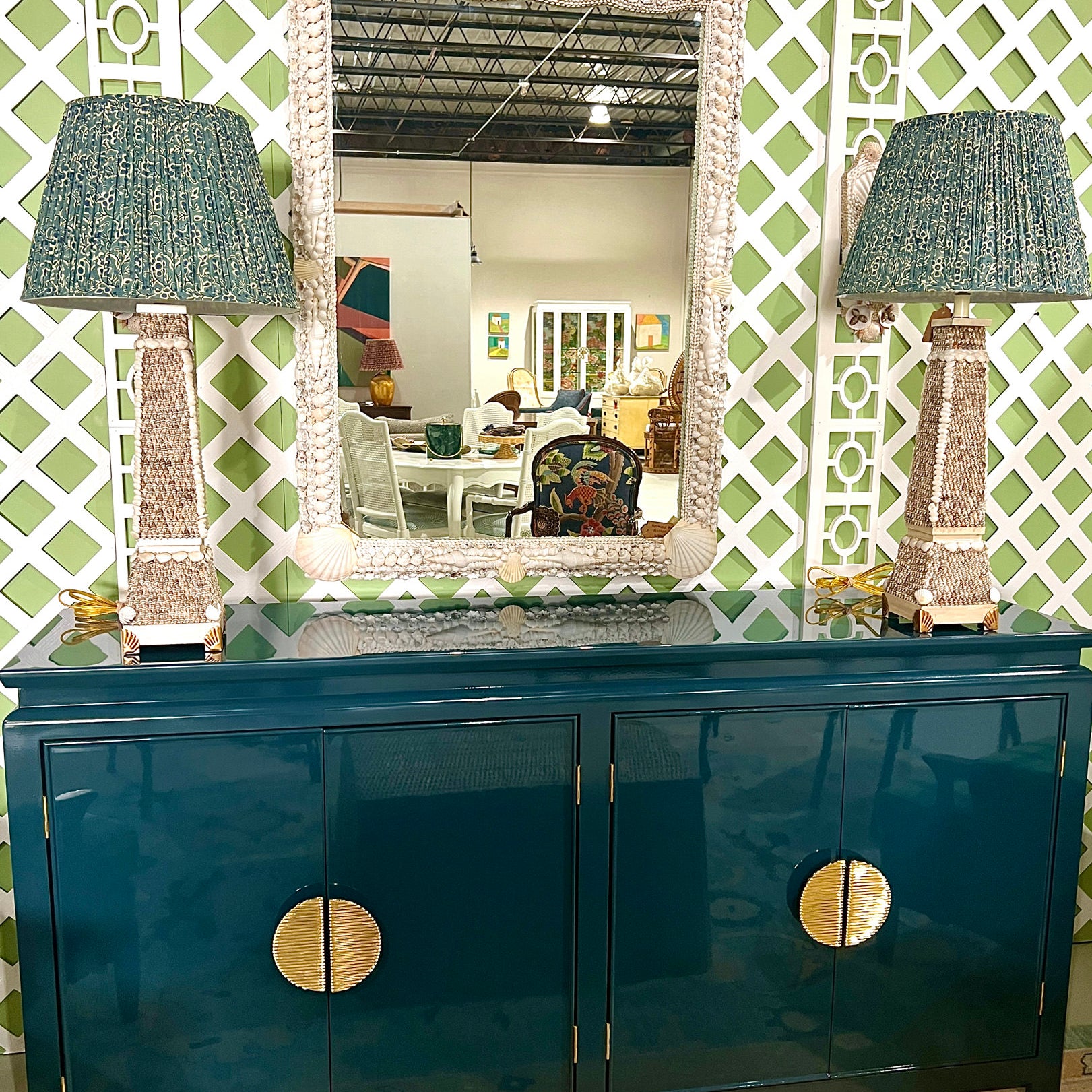 pleated lampshades and lamps on blue dresser with mirror in between lamps