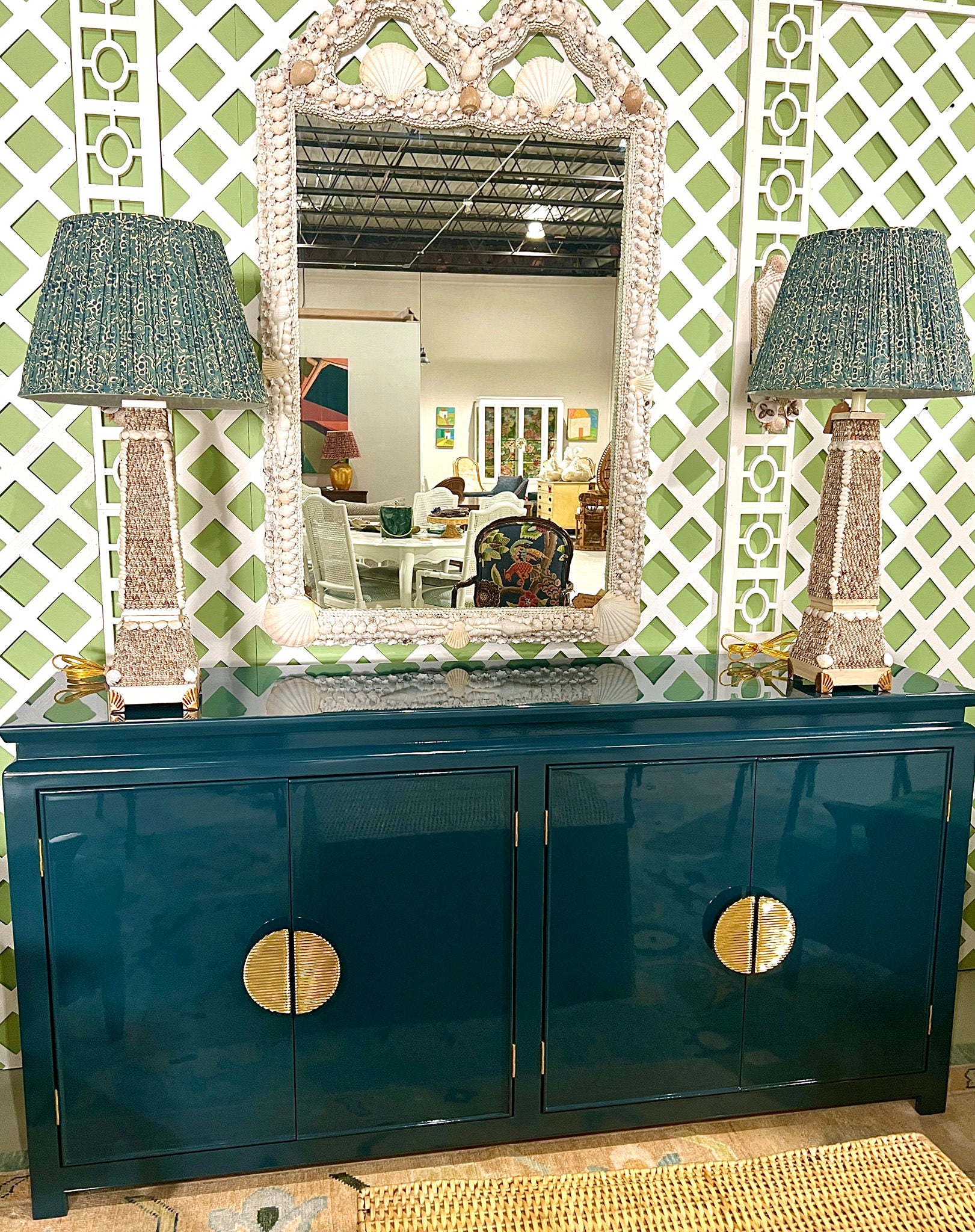 pleated lampshades and lamps on blue dresser with mirror in between lamps