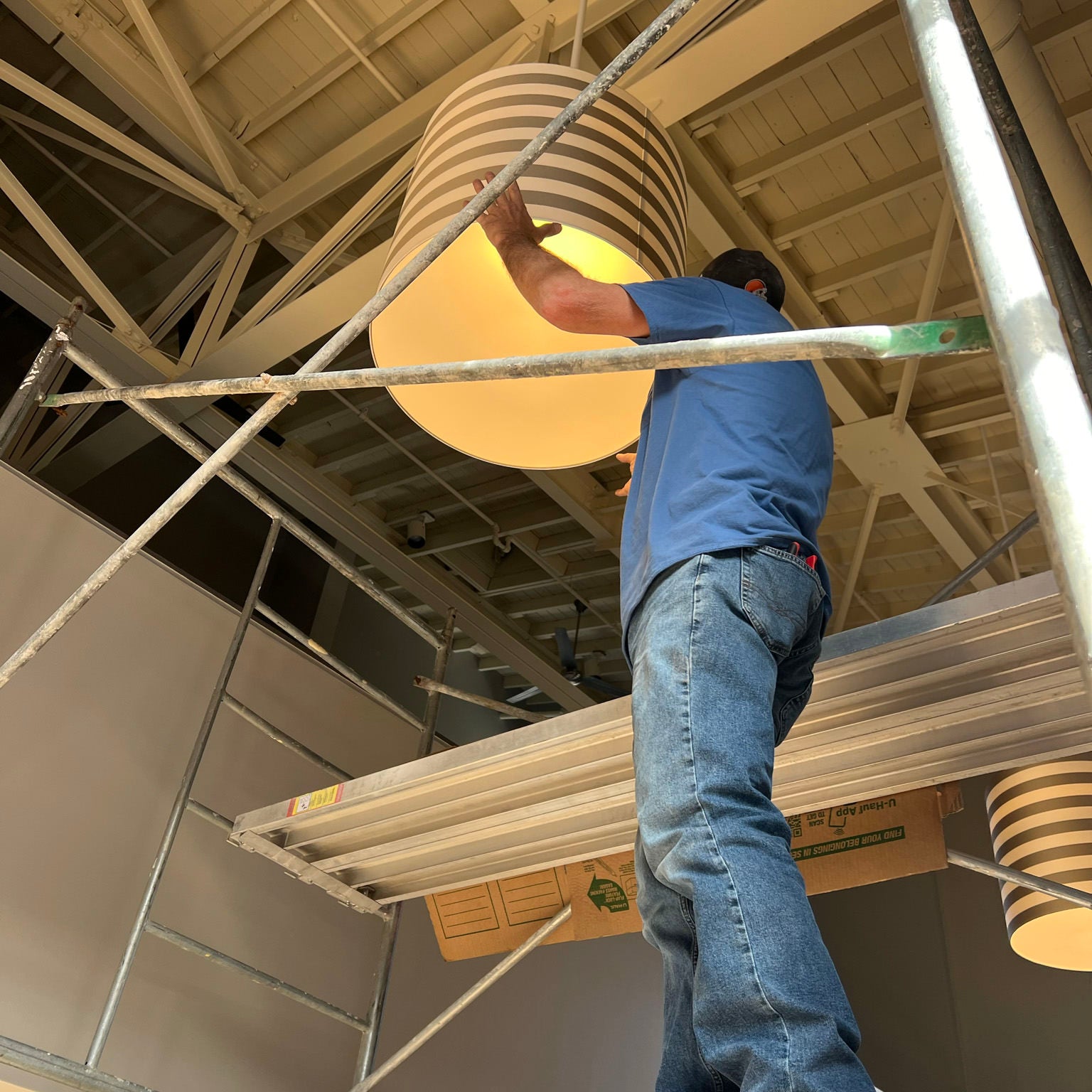 man hanging a lampshade fixture