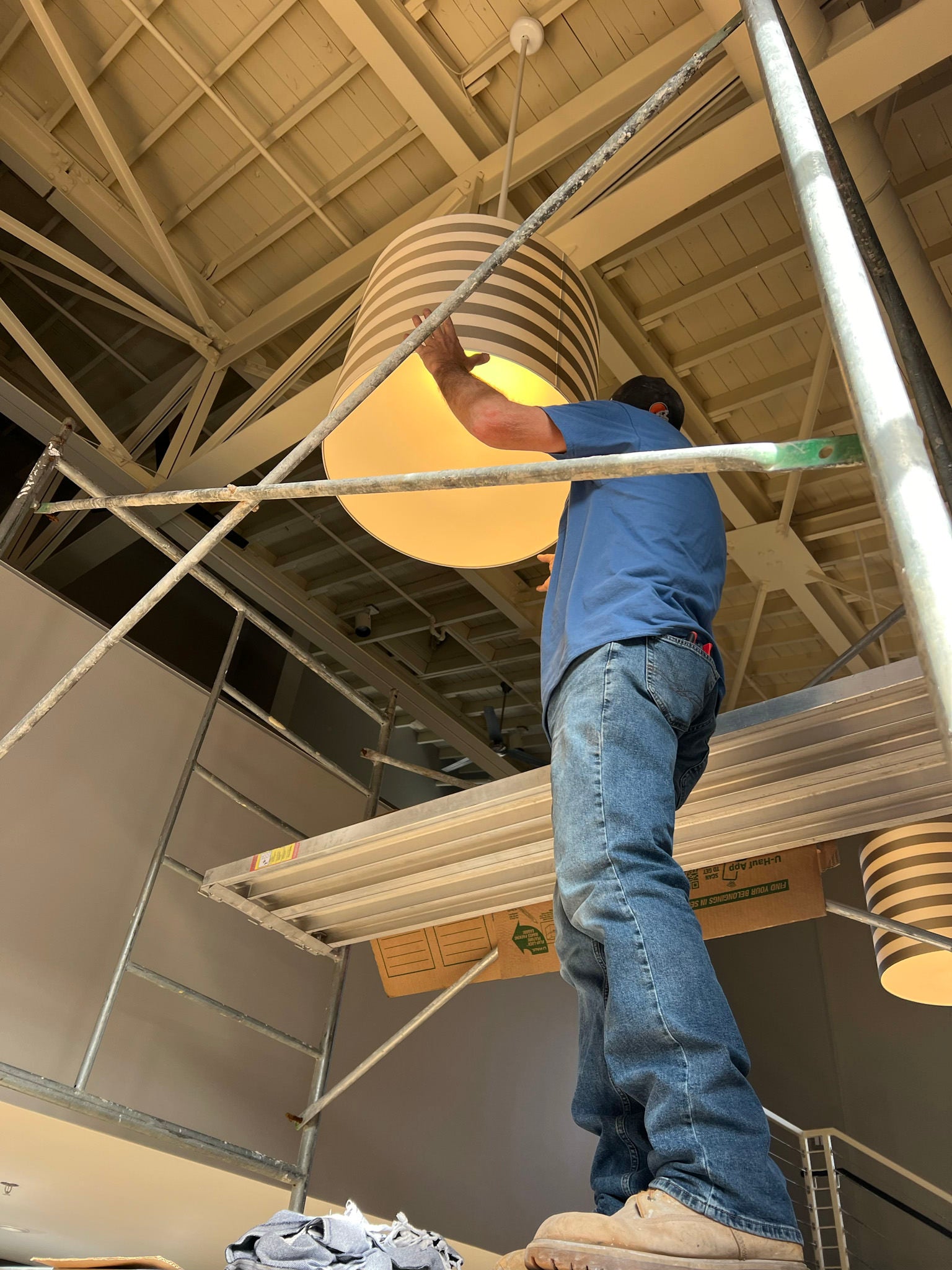 man hanging a lampshade fixture