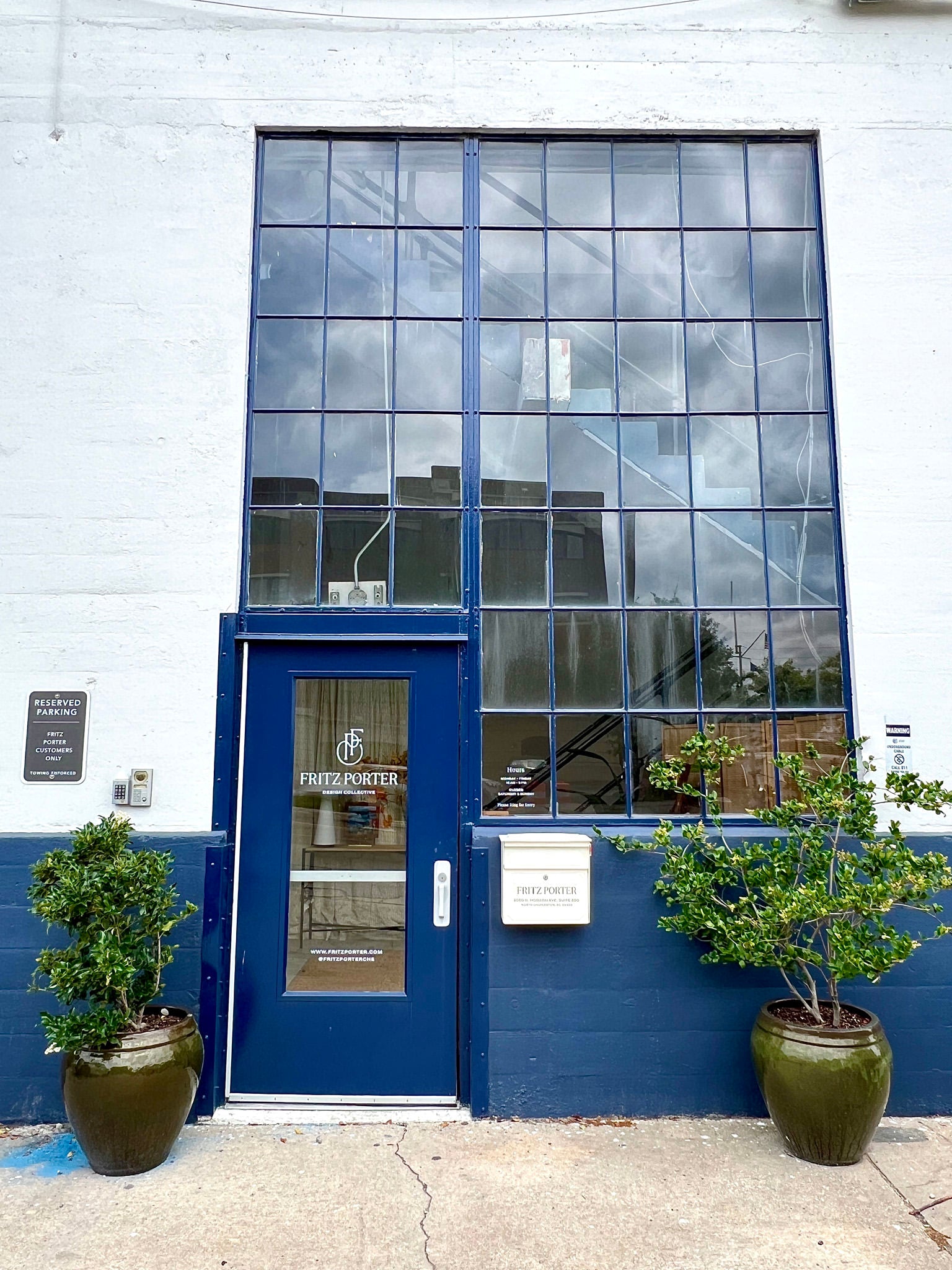 bibelot home physical location - blue door with two plants on either side of door