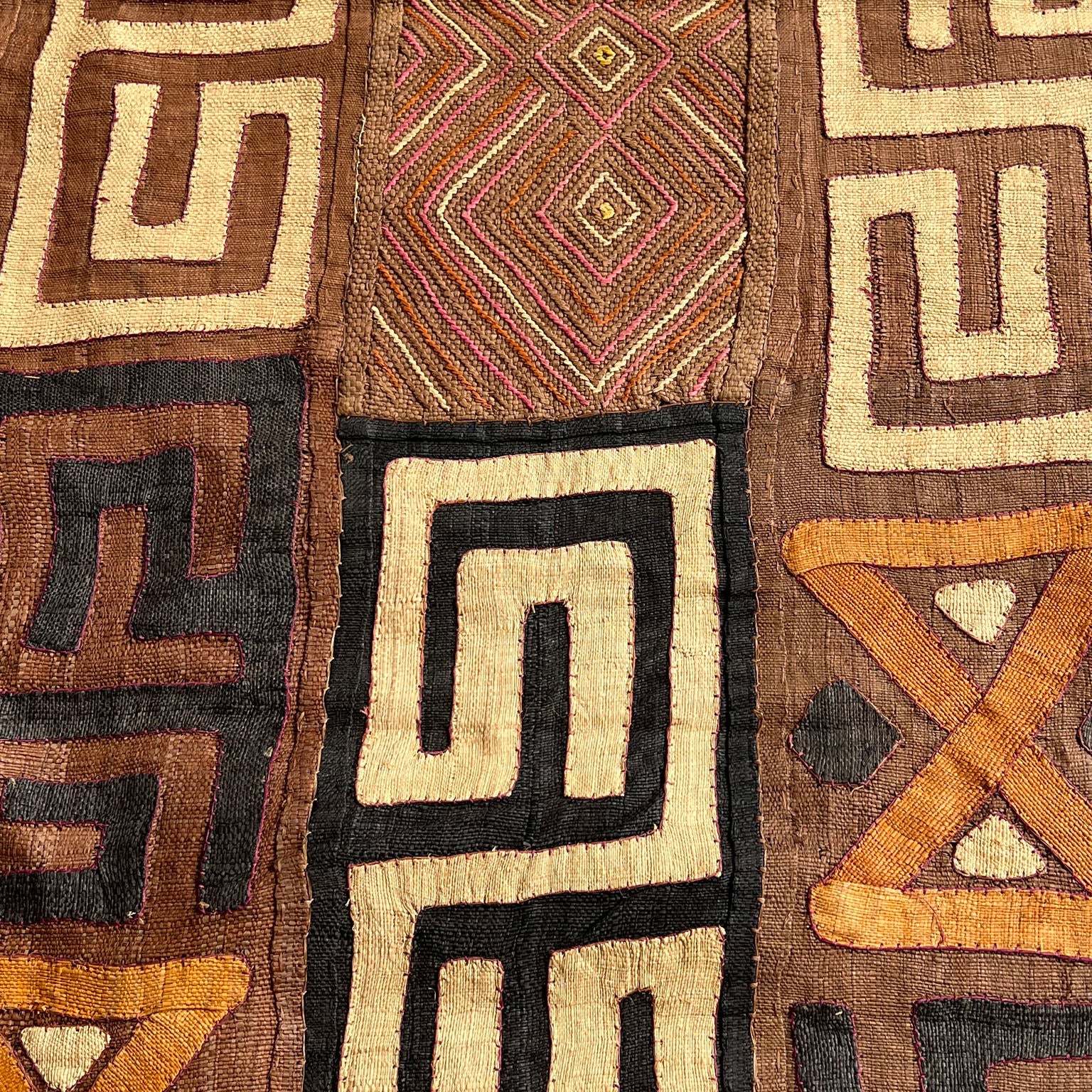 brown, black, light brown and orange kuba cloth
