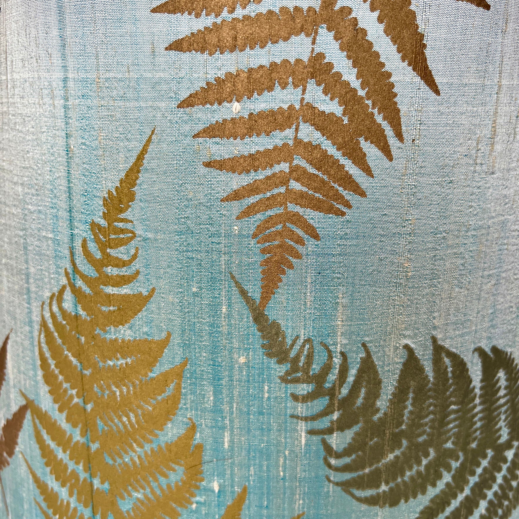 gold fern leaves on light blue fabric