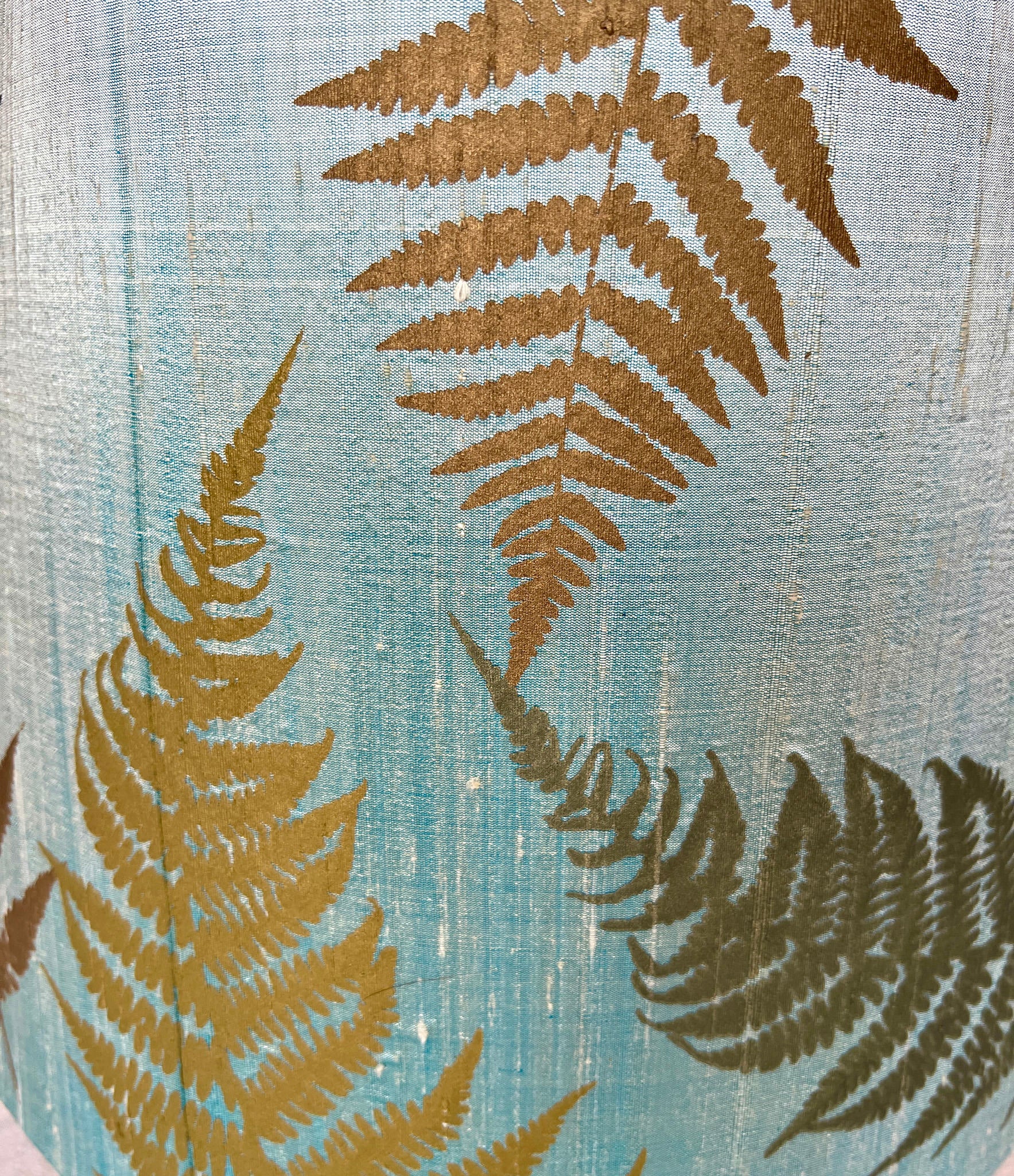 gold fern leaves on light blue fabric